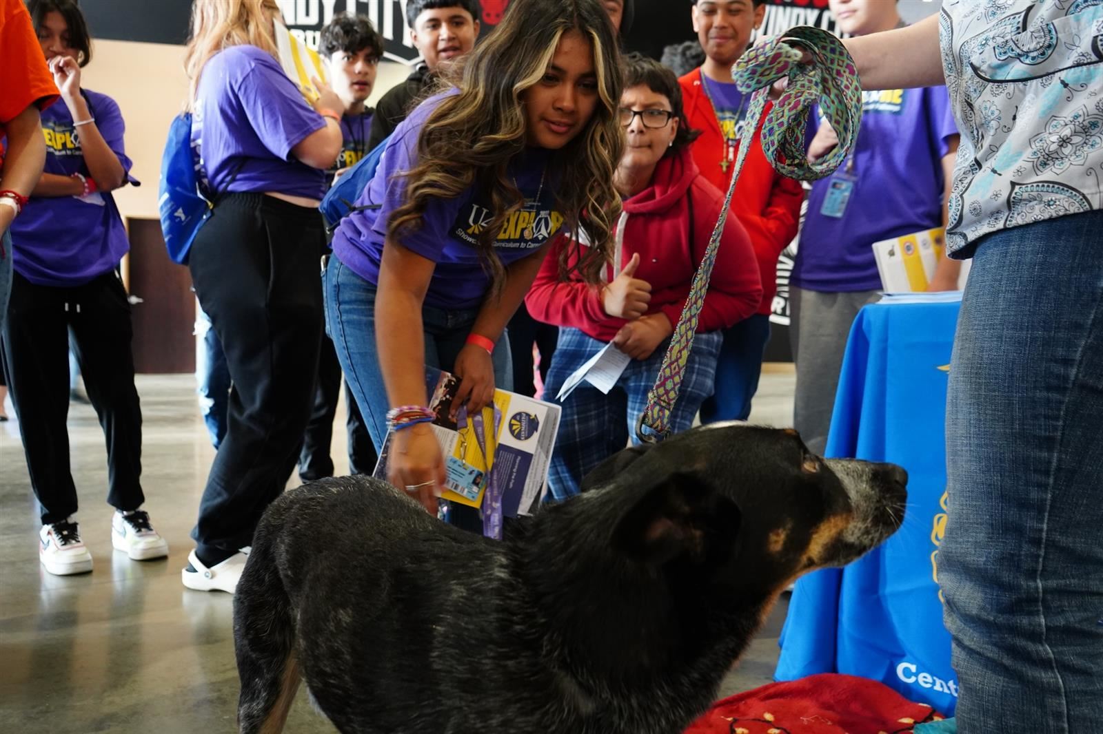  Students visit with a dog at the vet table exhibit at Explore 